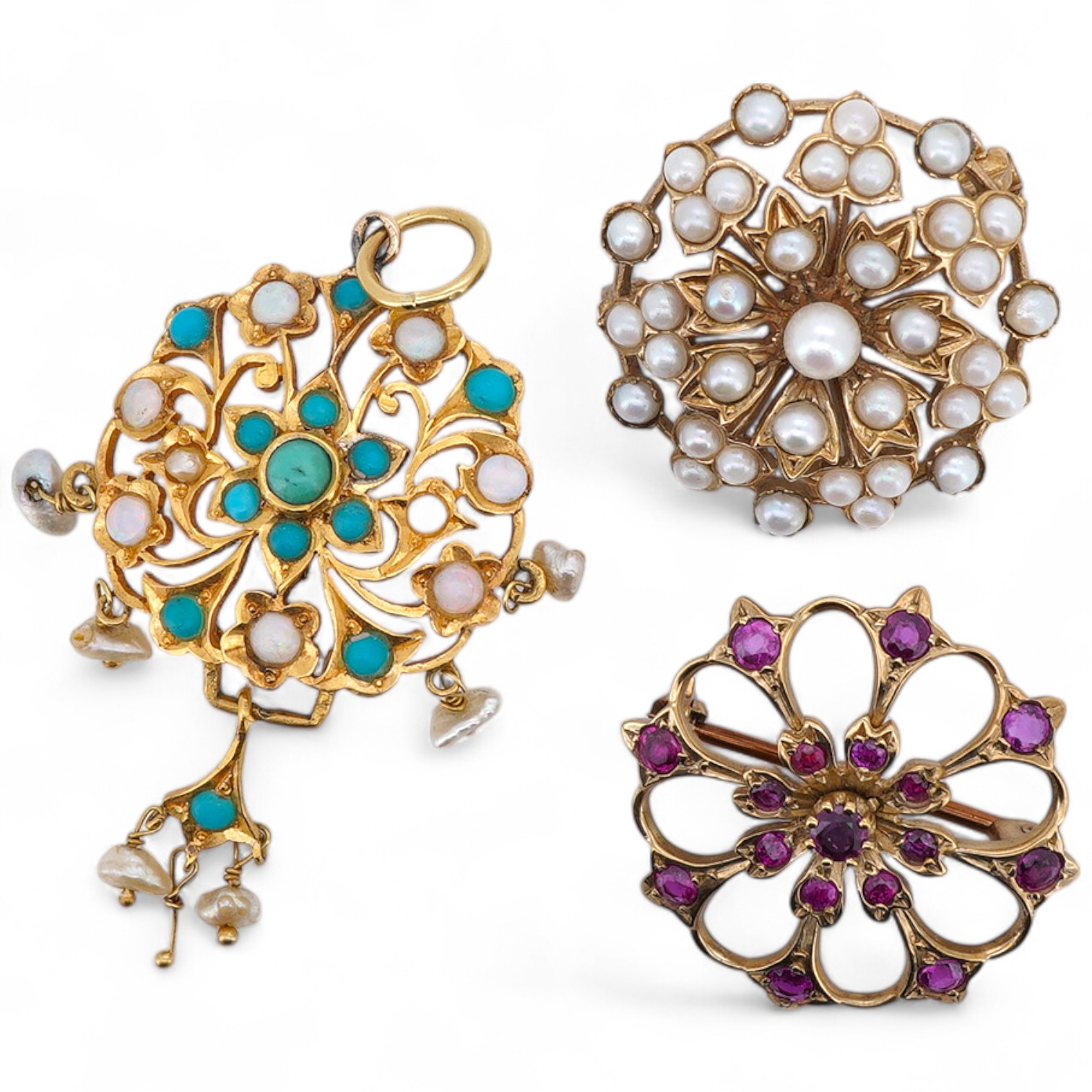 Two brooches and a pendant, each of floral design, the brooches set with circular-cut garnets, and seed pearls respectively each mounted in 9ct gold, British hallmarks, combined gross weight 11 grams, the pendant set wit